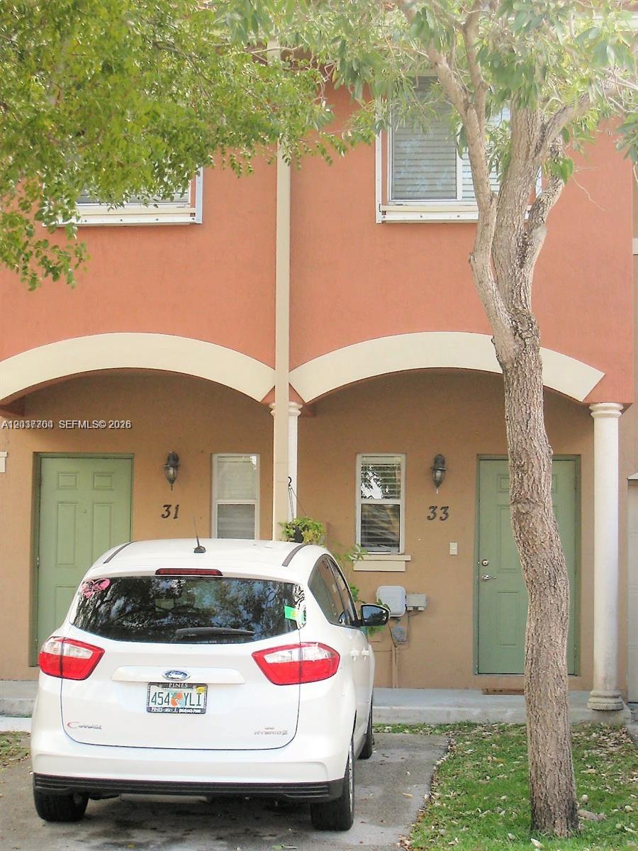 A white car is parked in front of two adjacent townhome entrances numbered 31 and 33 — 33 SE 3rd Ave, Hallandale Beach FL 33009, HALLANDALE BEACH, FL