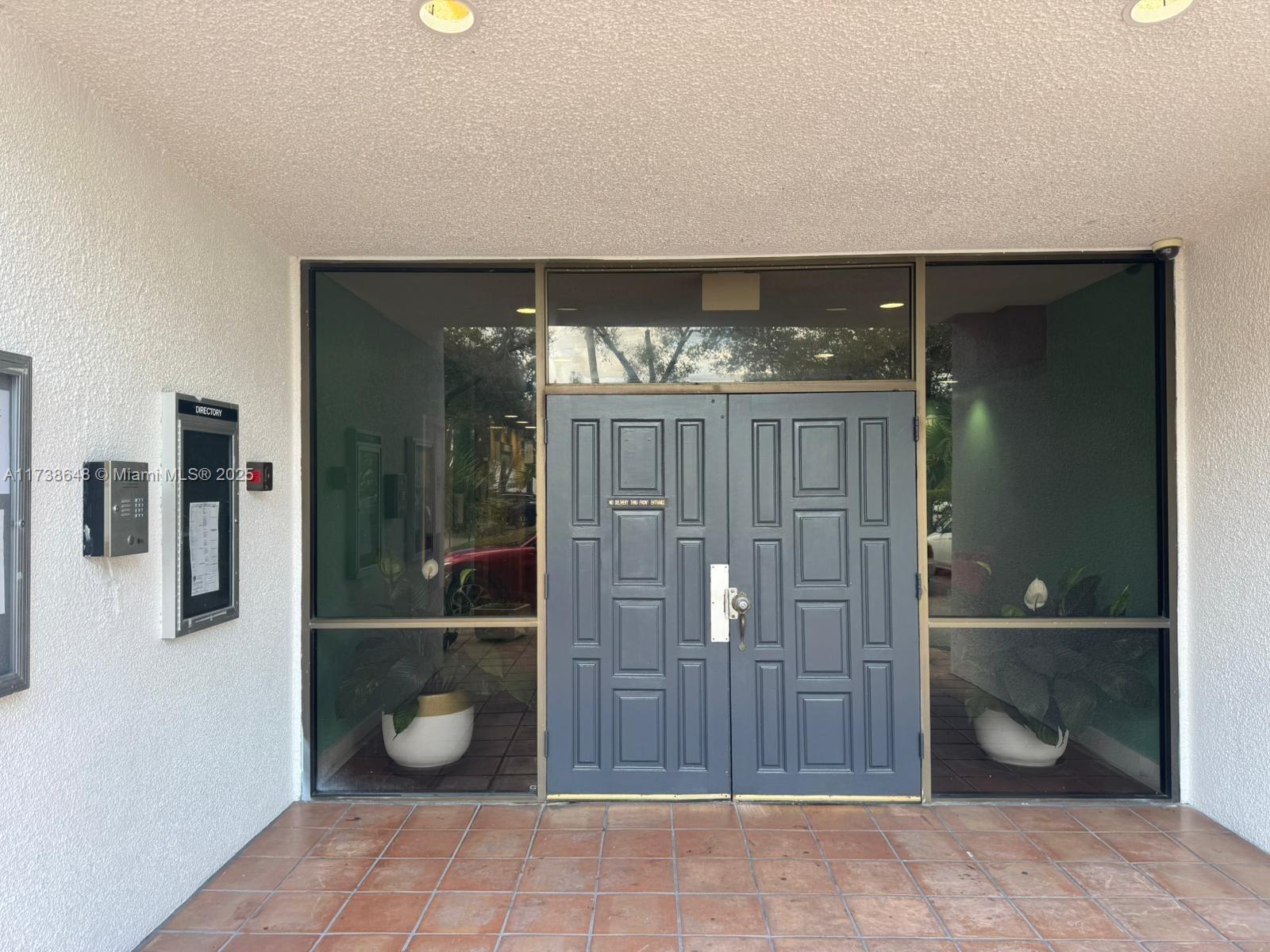A multi-story apartment building features a ground-level entrance, covered parking, and a red car parked outside — 3301 Spanish Moss Ter # 415, Lauderhill FL 33319, LAUDERHILL, FL