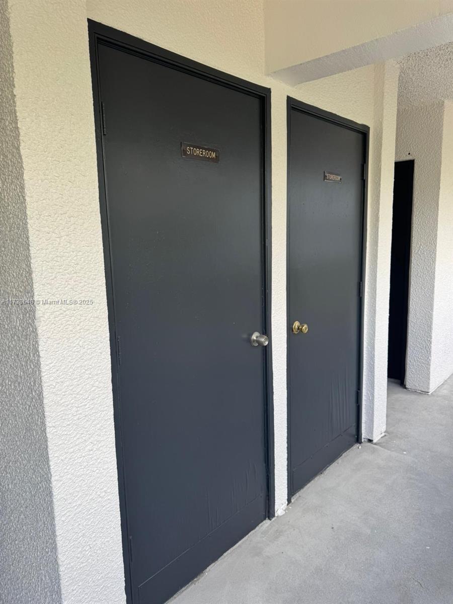 An interior view of a room with tiled floors, a staircase, and a glass-enclosed balcony — 3301 Spanish Moss Ter # 415, Lauderhill FL 33319, LAUDERHILL, FL