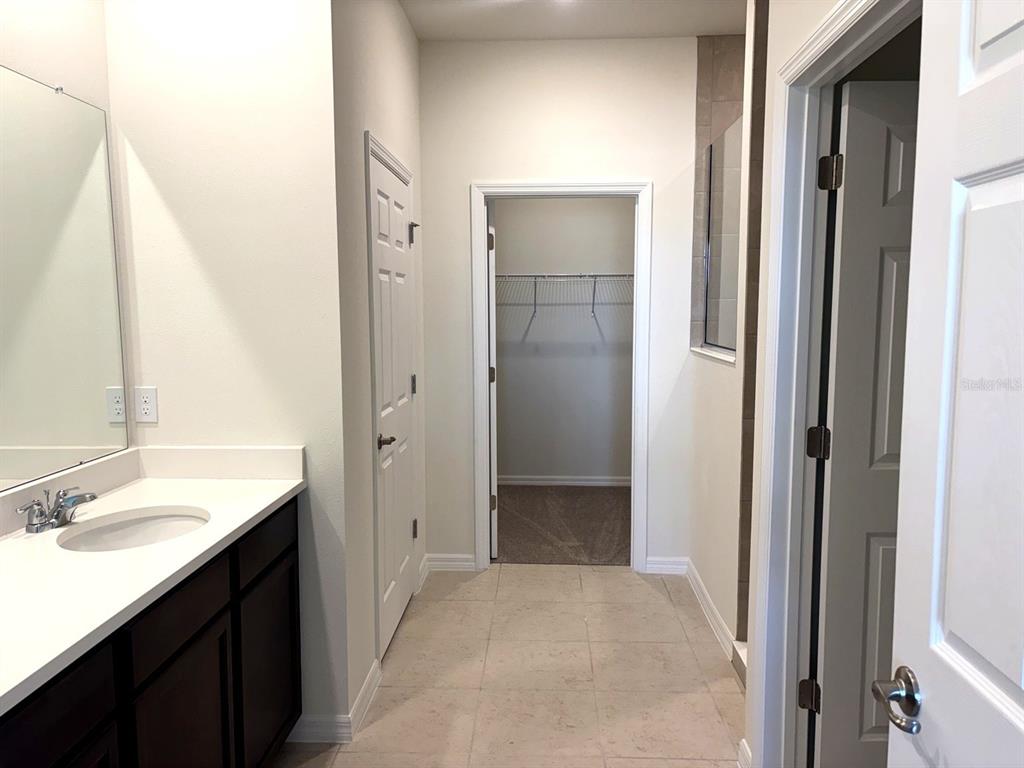 A bathroom vanity with a sink, a closet doorway, and a tiled floor — 2363 SELENIA STREET, LAKE ALFRED, FL