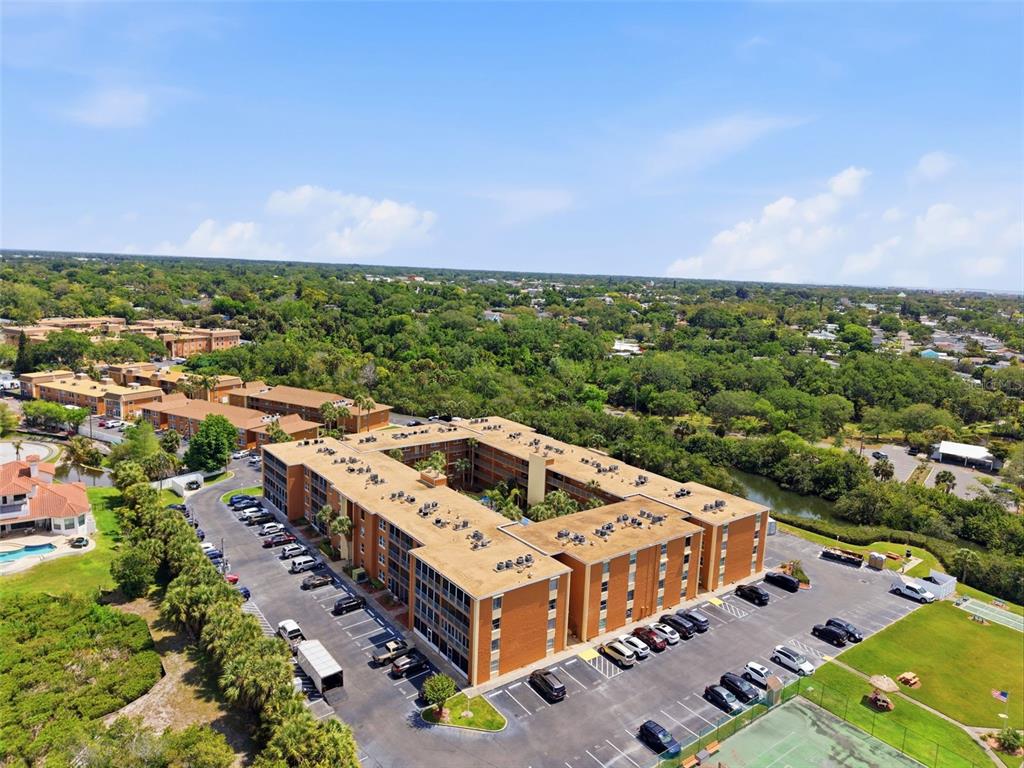 An aerial view shows a large, rectangular brick apartment complex with a central courtyard — 12760 INDIAN ROCKS ROAD UNIT 1065, LARGO, FL