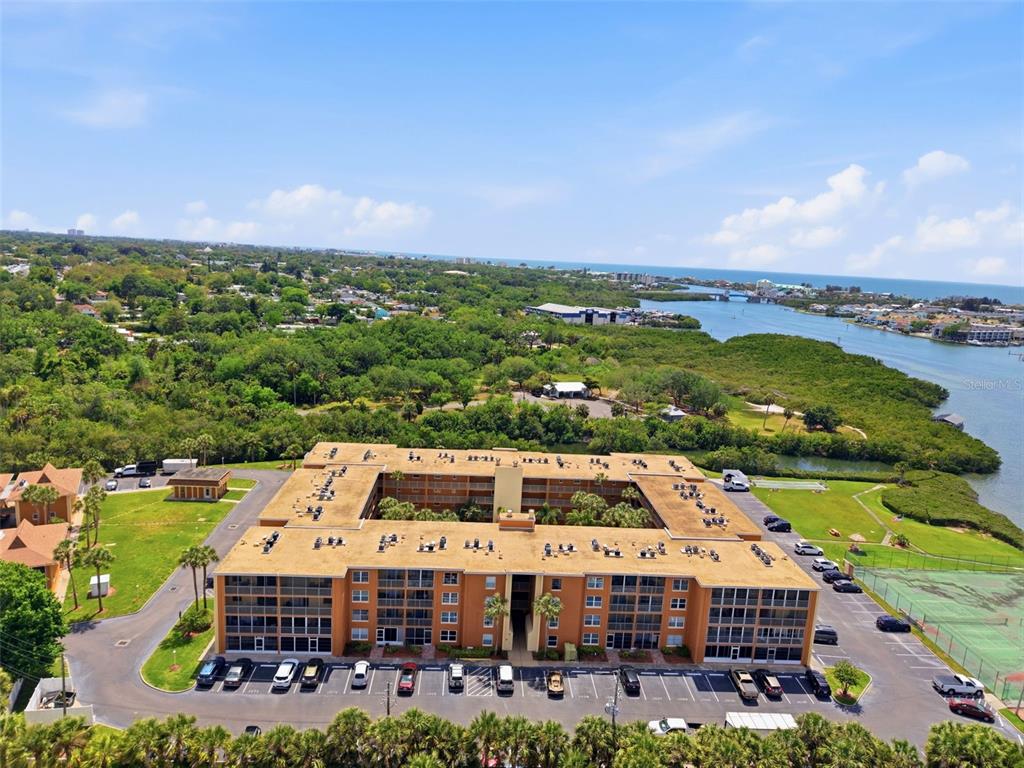 An aerial view shows a multi-story apartment building with a central courtyard and parking lot — 12760 INDIAN ROCKS ROAD UNIT 1065, LARGO, FL