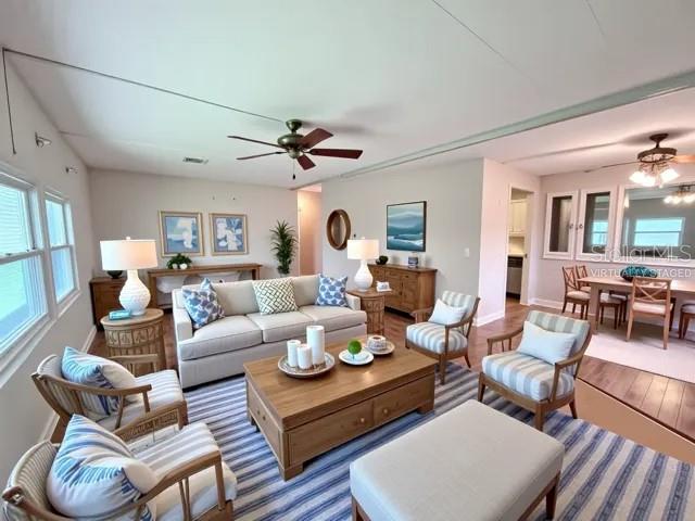 A living room with a beige sofa, two armchairs, a coffee table, and a ceiling fan — 427 HAWTHORNE BOULEVARD, LEESBURG, FL