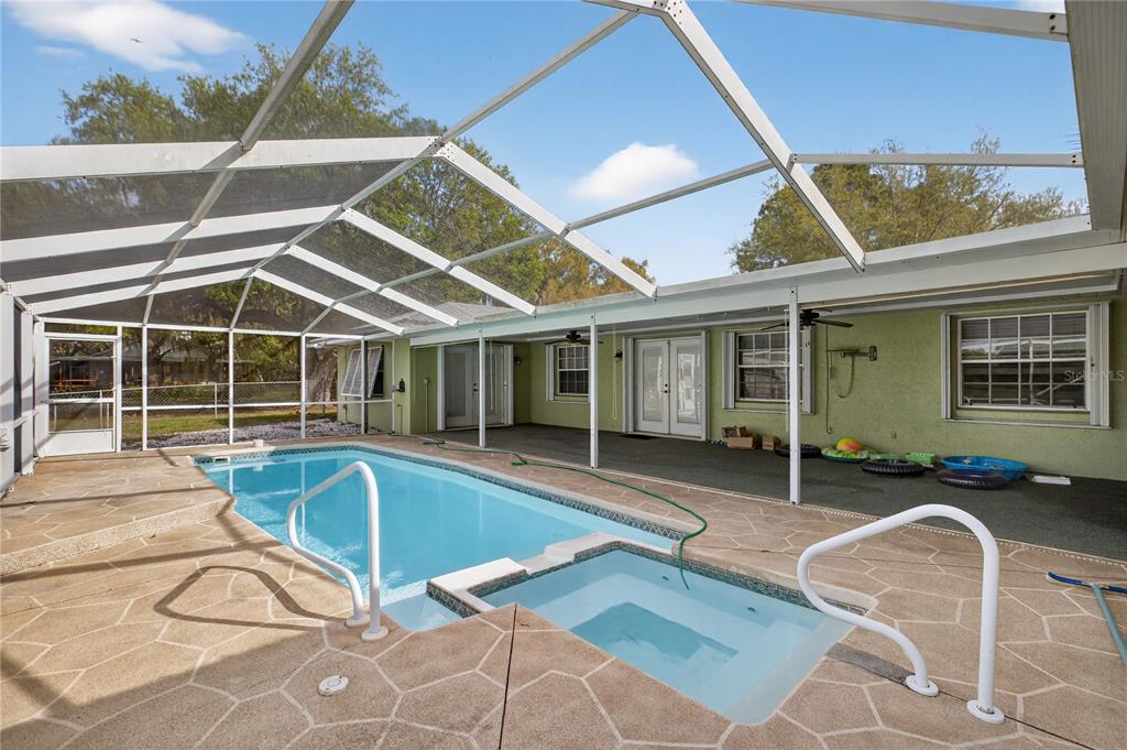 An outdoor swimming pool and spa are enclosed within a screened-in patio area — 2065 OAK BEACH BOULEVARD, SEBRING, FL