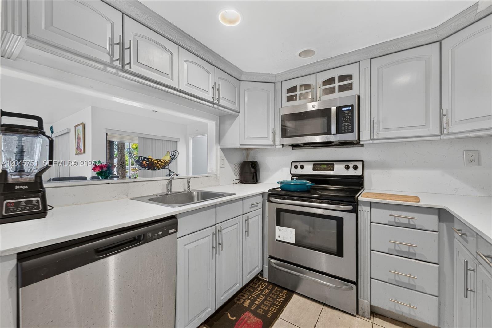 A kitchen features light gray cabinets, stainless steel appliances, and white countertops — 20065 NE 3rd Ct # 5, Miami FL 33179, MIAMI, FL