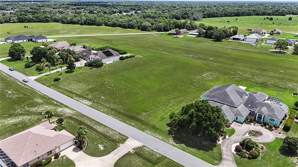 An aerial view shows a residential property with a large house and pool on acreage — 8491 SE 72ND AVENUE, OCALA, FL