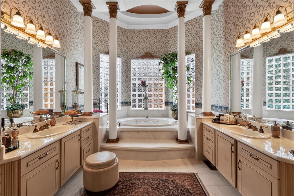 A primary bathroom features dual vanities, a central jetted tub, and decorative columns — 7957 S PARK PLACE, ORLANDO, FL