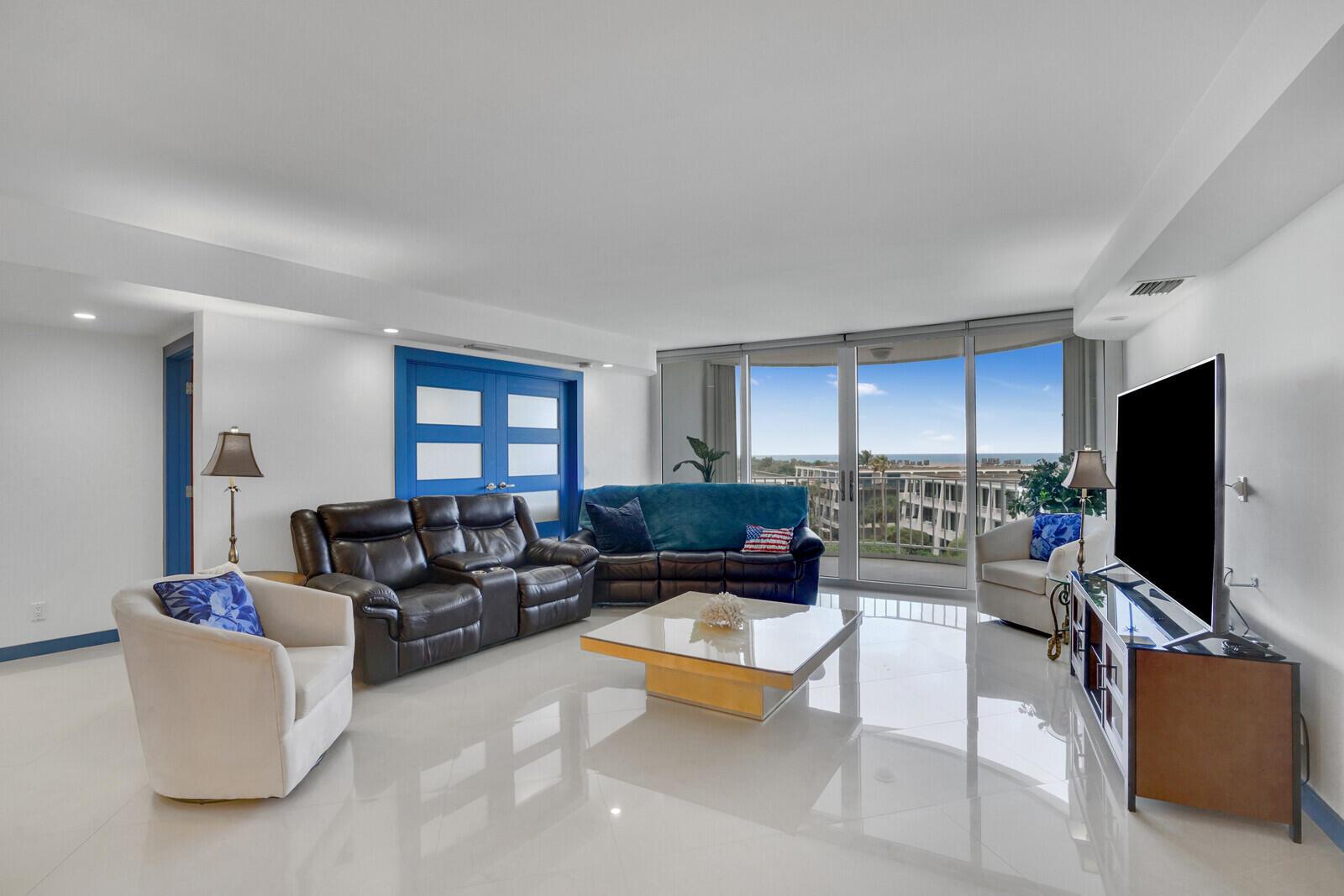 A living room features white tile floors, a dark leather sofa, and floor-to-ceiling windows — 2295 S Ocean Boulevard # 619, Palm Beach FL 33480, PALM BEACH, FL