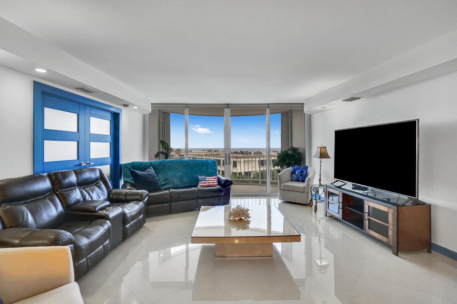 A living room features a dark leather sofa, glass coffee table, and large balcony windows — 2295 S Ocean Boulevard # 619, Palm Beach FL 33480, PALM BEACH, FL