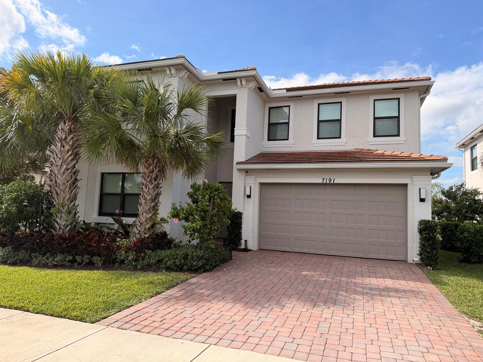 A two-story house with a beige stucco exterior, a tiled roof, and a paved driveway — 7191 Montereal Path, Lake Worth FL 33463, LAKE WORTH, FL