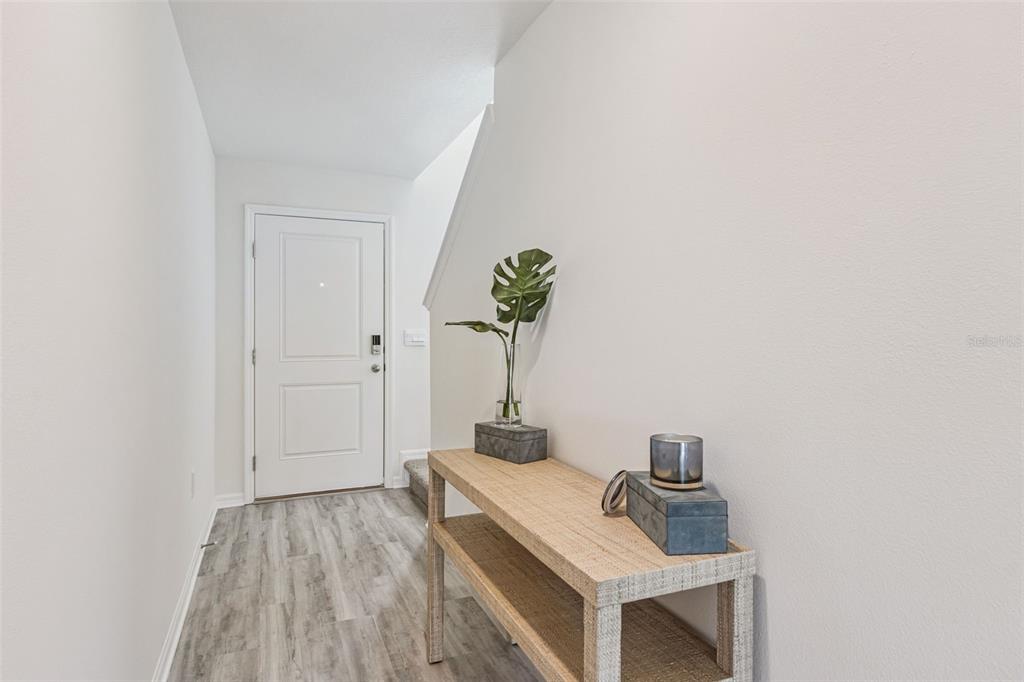 A light-filled entryway features wood-look flooring, a console table, and a white front door — 4707 TONY STREET, LAKE WALES, FL