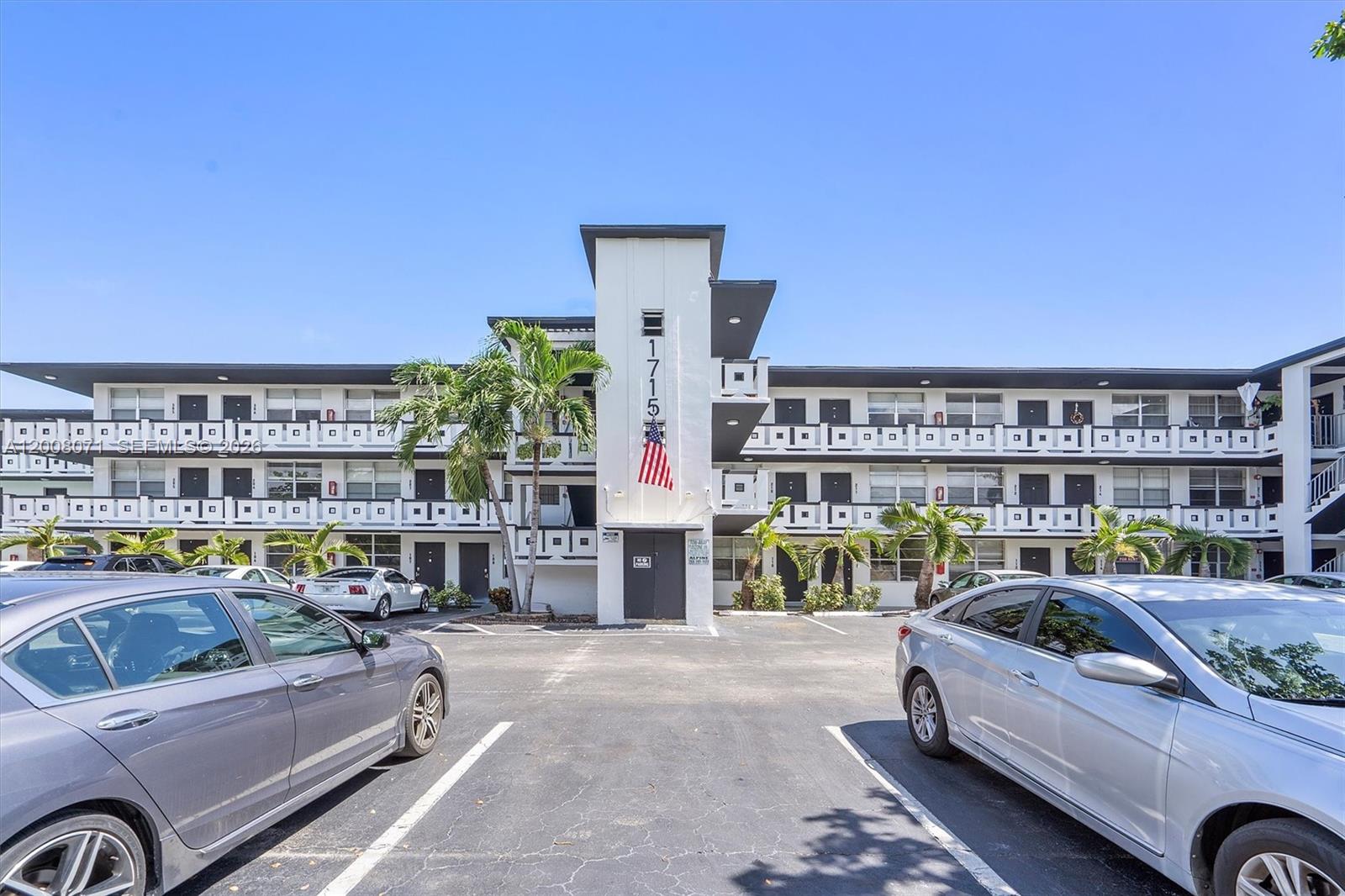 A three-story apartment building with a central tower and a parking lot in front — 1715 N 16th Ave # 102, Hollywood FL 33020, HOLLYWOOD, FL