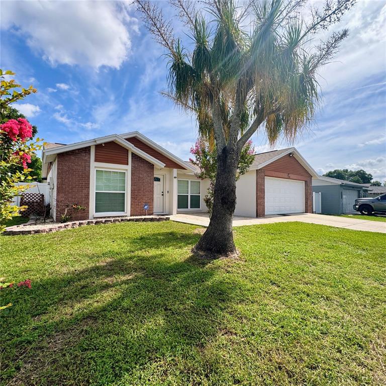 A single-story brick and stucco house features a front lawn with a large palm tree — 726 STILLVIEW CIRCLE, BRANDON, FL