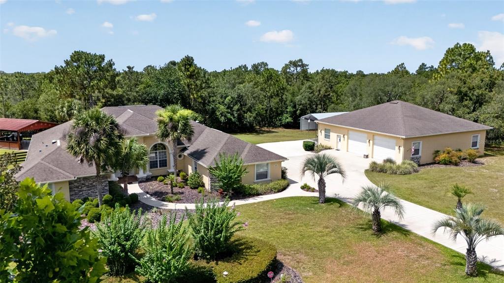 An aerial view shows a house and a detached garage surrounded by trees and landscaping — 4348 W BONANZA DRIVE, BEVERLY HILLS, FL