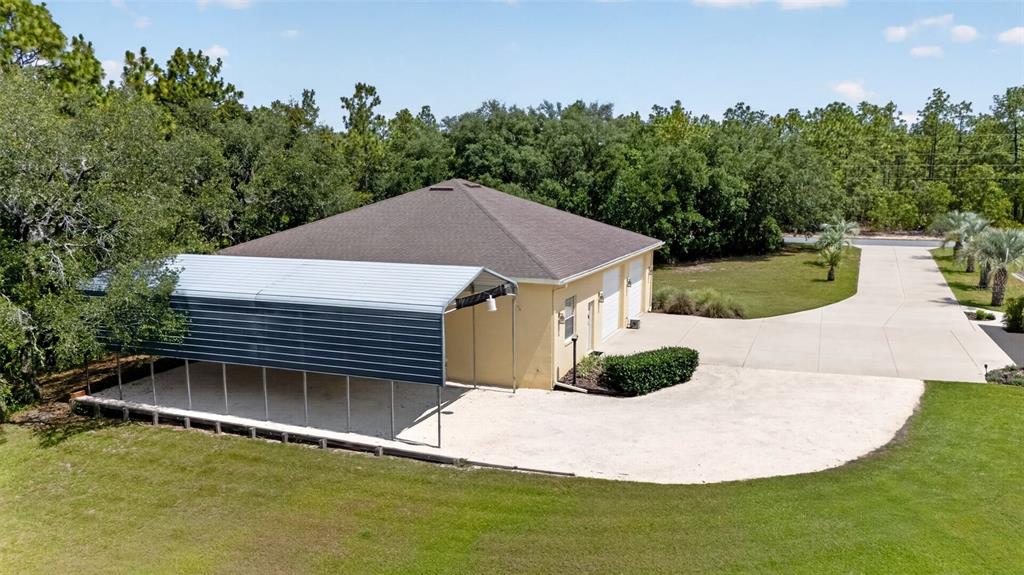 An aerial view shows a detached garage with a metal carport and a concrete driveway — 4348 W BONANZA DRIVE, BEVERLY HILLS, FL