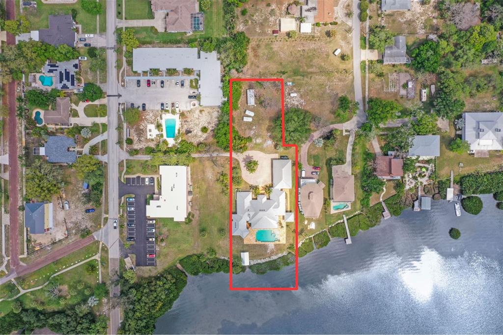 An aerial view shows a waterfront house with a pool, circular driveway, and large backyard — 1721 GULF ROAD, TARPON SPRINGS, FL