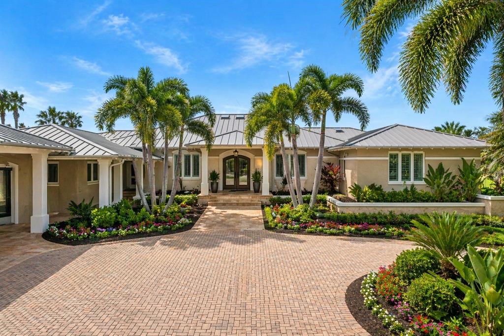A single-story house with a metal roof, palm trees, and a brick paver driveway — 1721 GULF ROAD, TARPON SPRINGS, FL