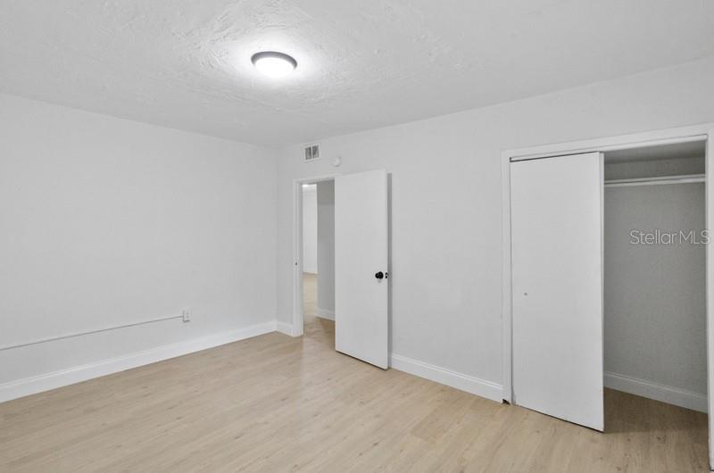 A bedroom with light wood-look flooring, white walls, a ceiling light, and a closet — 2608 E CAYUGA STREET, TAMPA, FL