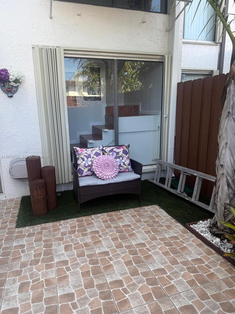 A small patio features tiled flooring, artificial grass, a wicker bench, and a metal ladder — 6524 SW 114th Ave # 6524, Miami FL 33173, MIAMI, FL