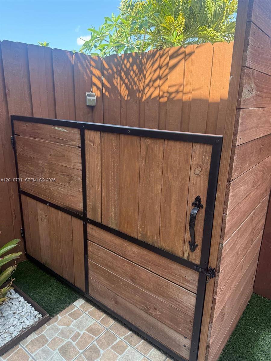 A wooden outdoor enclosure features a black metal frame and a decorative handle — 6524 SW 114th Ave # 6524, Miami FL 33173, MIAMI, FL