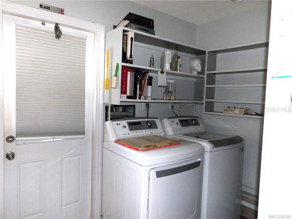 A laundry room features a white washer and dryer, open shelving, and a glass-paneled door — 3822 E PARSONS POINT ROAD, HERNANDO, FL