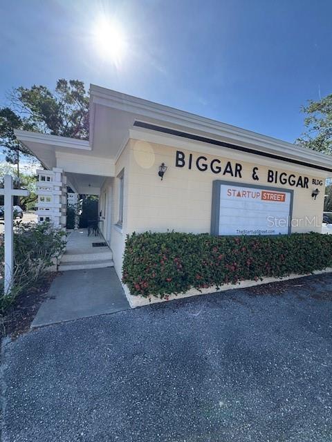 Exterior view of a light-colored commercial building with a sign reading Biggar & Biggar — 3022 W SWANN AVENUE, TAMPA, FL