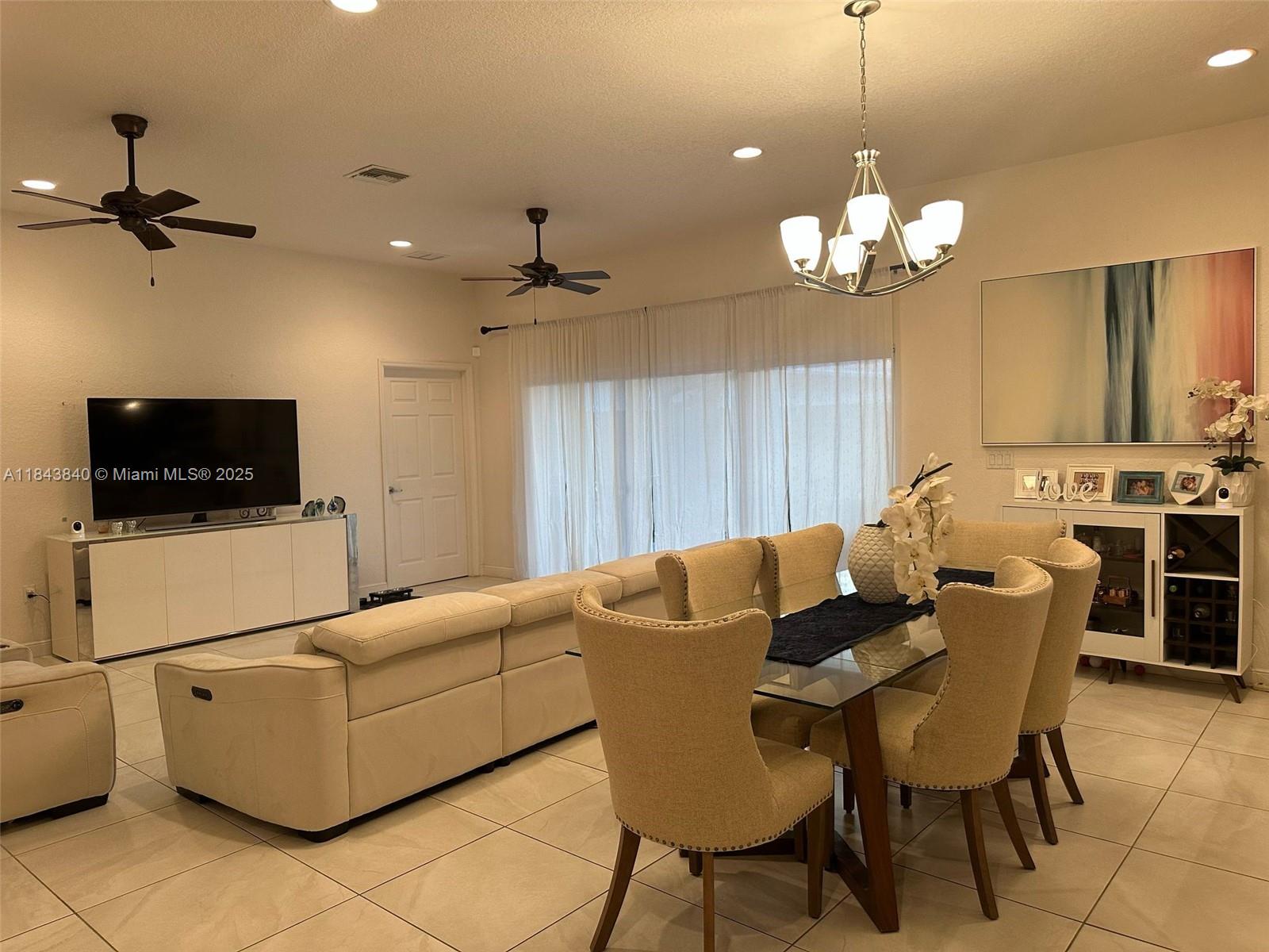A living and dining room features light-colored furniture, tile flooring, and a glass dining table — 210 SW 4th St # 210, Dania Beach FL 33004, DANIA BEACH, FL