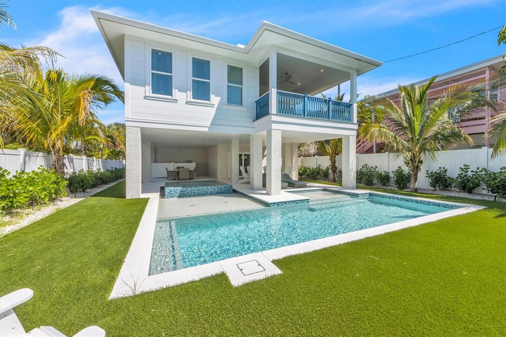 A two-story house with a raised porch, swimming pool, and artificial turf backyard — 518 SPRING AVENUE, ANNA MARIA, FL