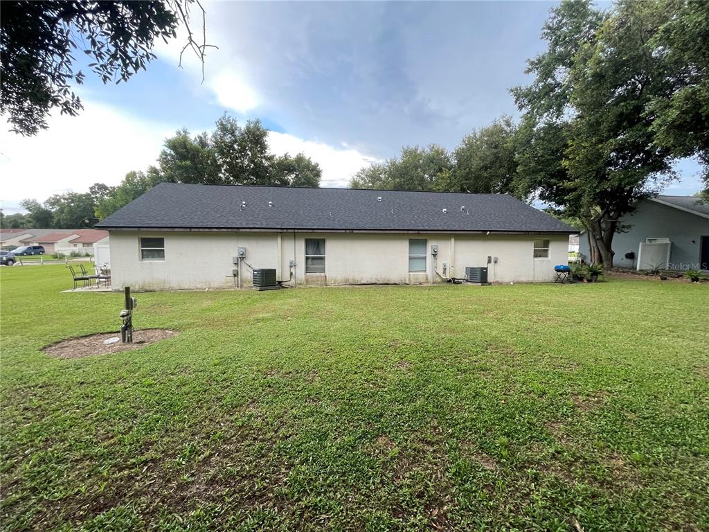 The rear exterior of a single-story house with a dark shingled roof and lawn — 1783 108TH LANE UNIT A & B, OCALA, FL