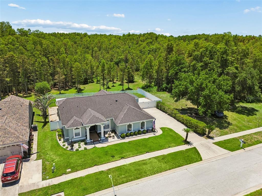 An aerial view shows a single-story house with a gray roof and a large backyard — 2154 GROUND SQUIRREL DRIVE, NEW PORT RICHEY, FL