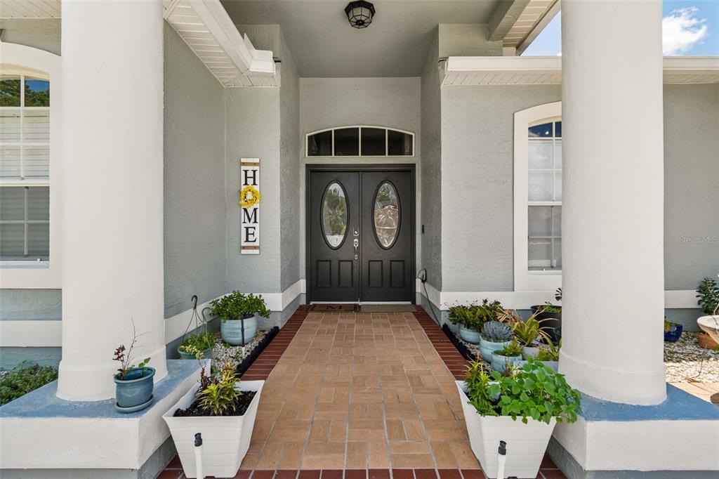 A front entryway features a brick walkway leading to double doors with oval glass inserts — 2154 GROUND SQUIRREL DRIVE, NEW PORT RICHEY, FL