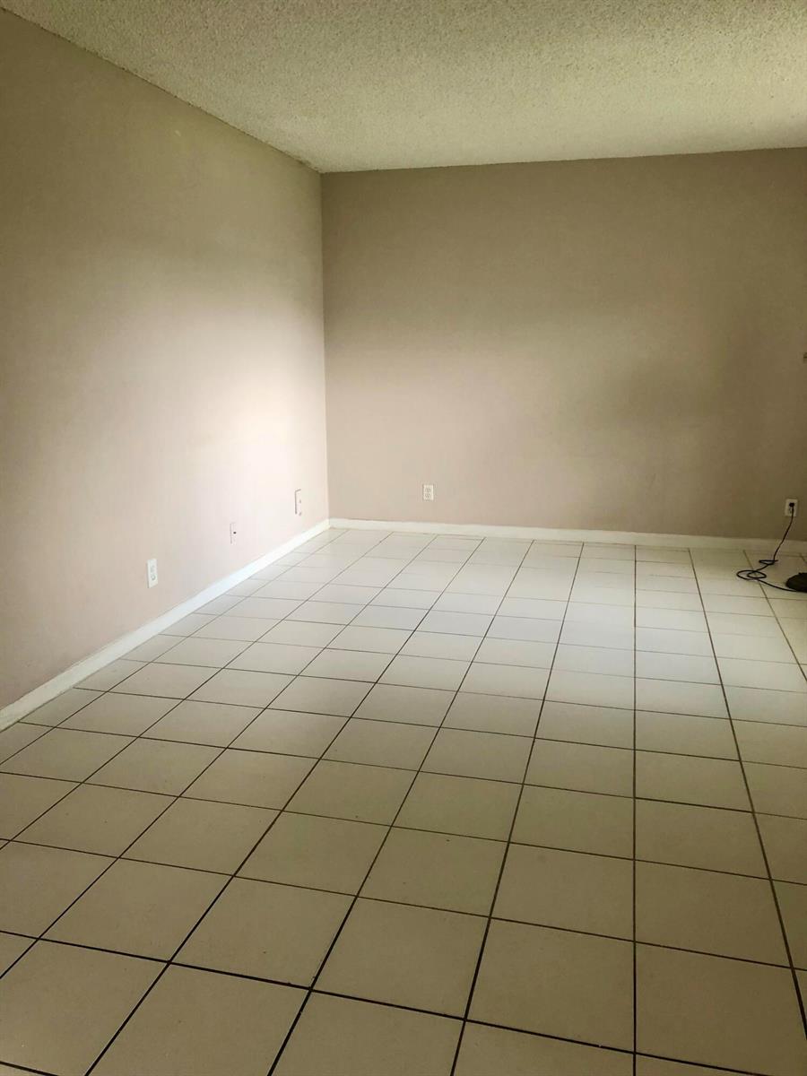 An empty room with light-colored walls, white baseboards, and large square floor tiles — 500 NE 2nd Street # 204, Dania Beach FL 33004, DANIA BEACH, FL