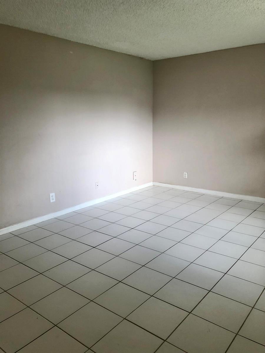 An empty room features light-colored tile flooring, beige walls, and a textured white ceiling — 500 NE 2nd Street # 204, Dania Beach FL 33004, DANIA BEACH, FL