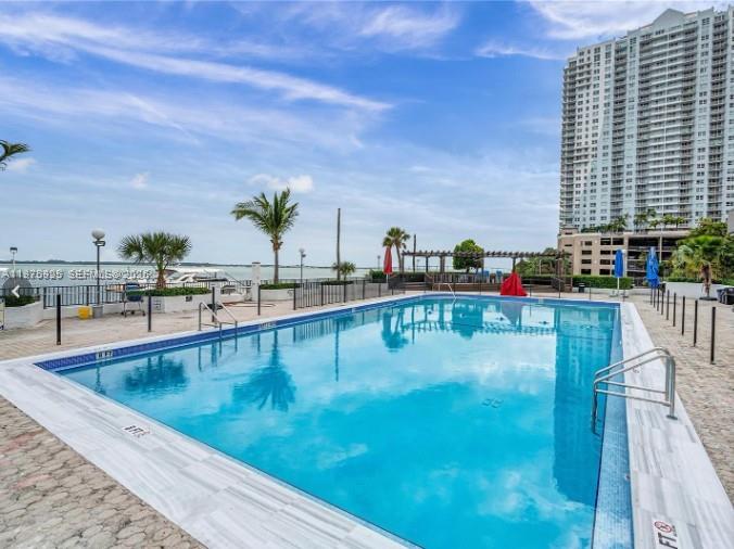 A rectangular swimming pool sits on a paved deck overlooking a bay and high-rise building — 999 Brickell Bay Dr # 2007, Miami FL 33131, MIAMI, FL