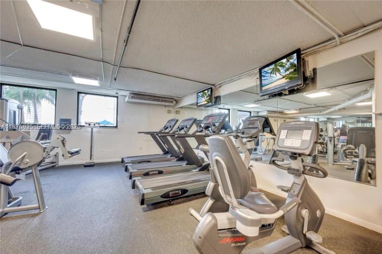 A gym features multiple treadmills, a stationary bike, and wall-mounted televisions — 999 Brickell Bay Dr # 2007, Miami FL 33131, MIAMI, FL