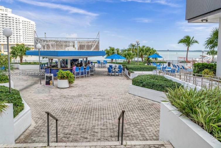 An outdoor patio area features a bar, seating, and views of the water and buildings — 999 Brickell Bay Dr # 2007, Miami FL 33131, MIAMI, FL