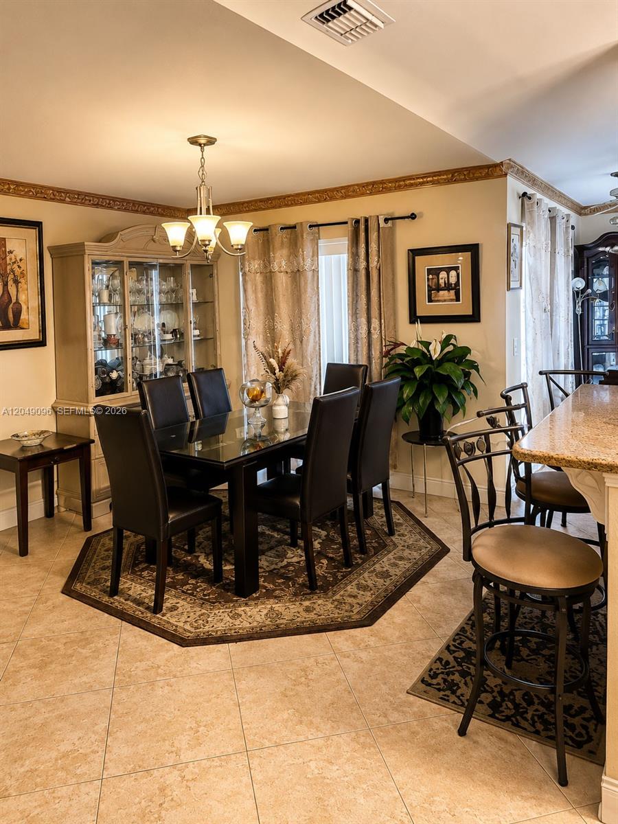 A dining room features a glass-top table, dark chairs, a hutch, and tile flooring — 2903 19TH ST SW, Lehigh Acres FL 33976, LEHIGH ACRES, FL