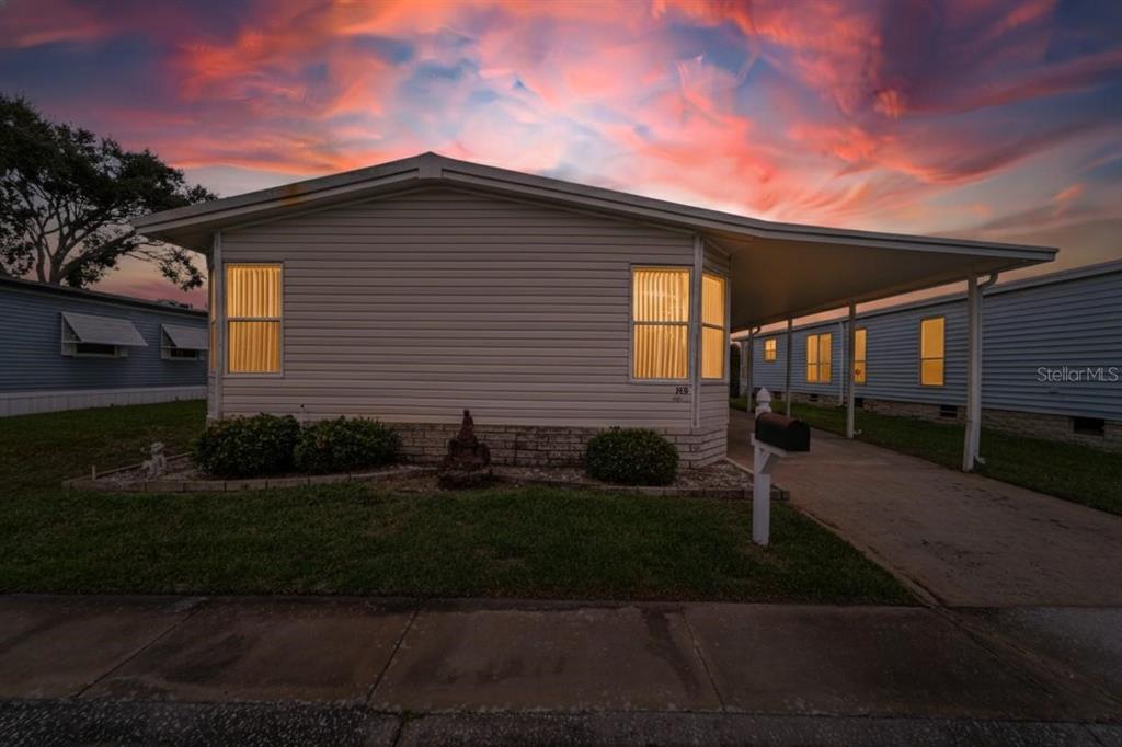 A single-story manufactured home with a carport and a mailbox at sunset — 1001 STARKEY ROAD, LOT#355, LARGO, FL
