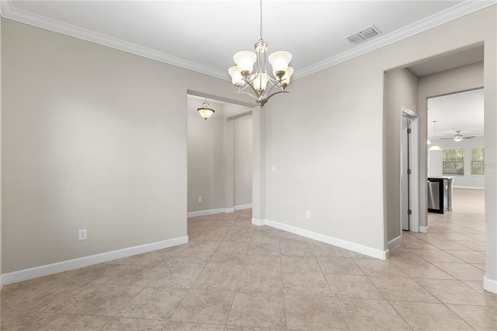 A dining area with tile flooring, a chandelier, and an arched entryway to another room — 3147 CALVANO DRIVE, LAND O LAKES, FL
