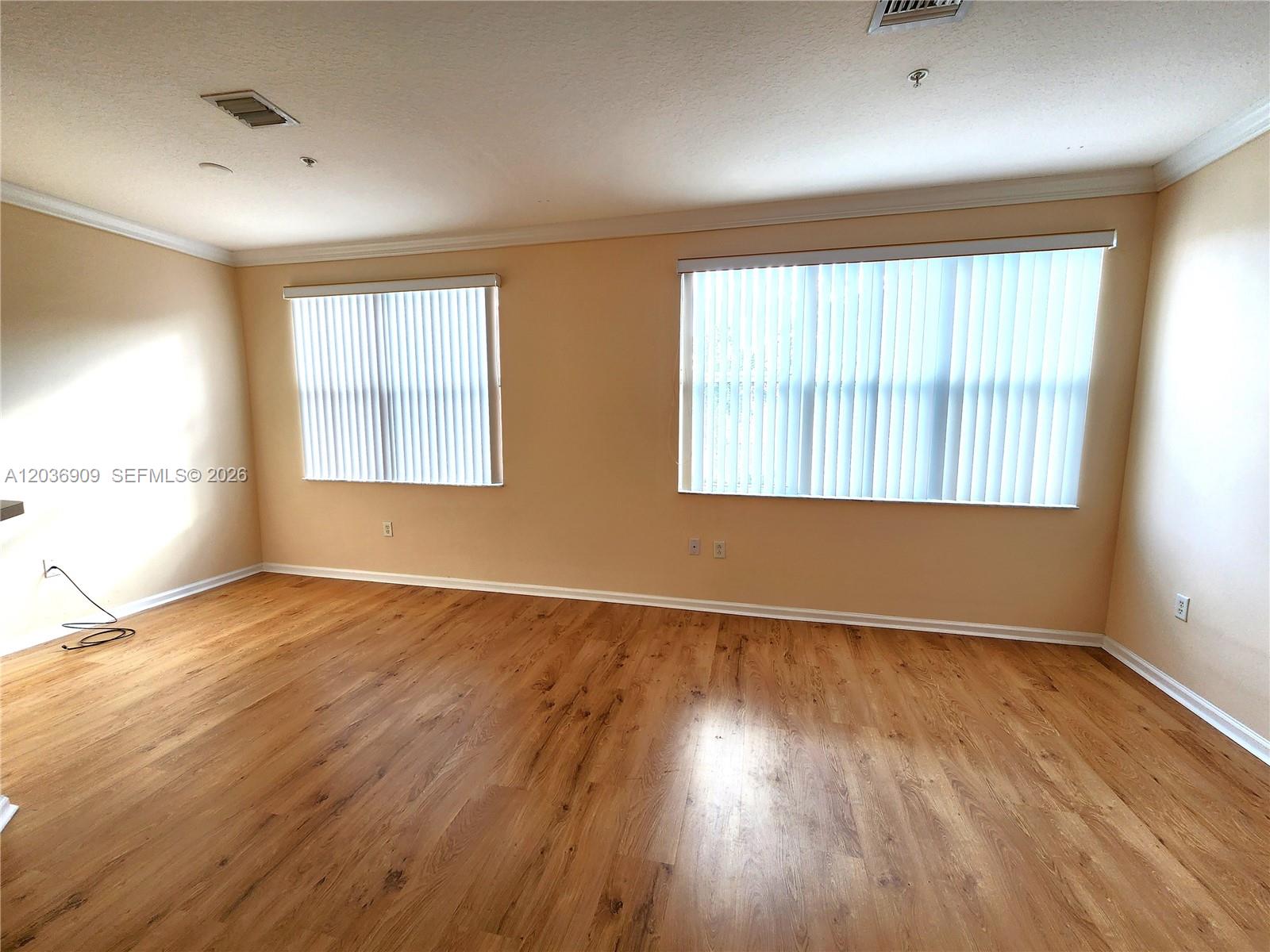 An empty room features light-colored walls, wood-look flooring, and two windows with vertical blinds — 4602 SW 160th Ave # 524, Miramar FL 33027, MIRAMAR, FL