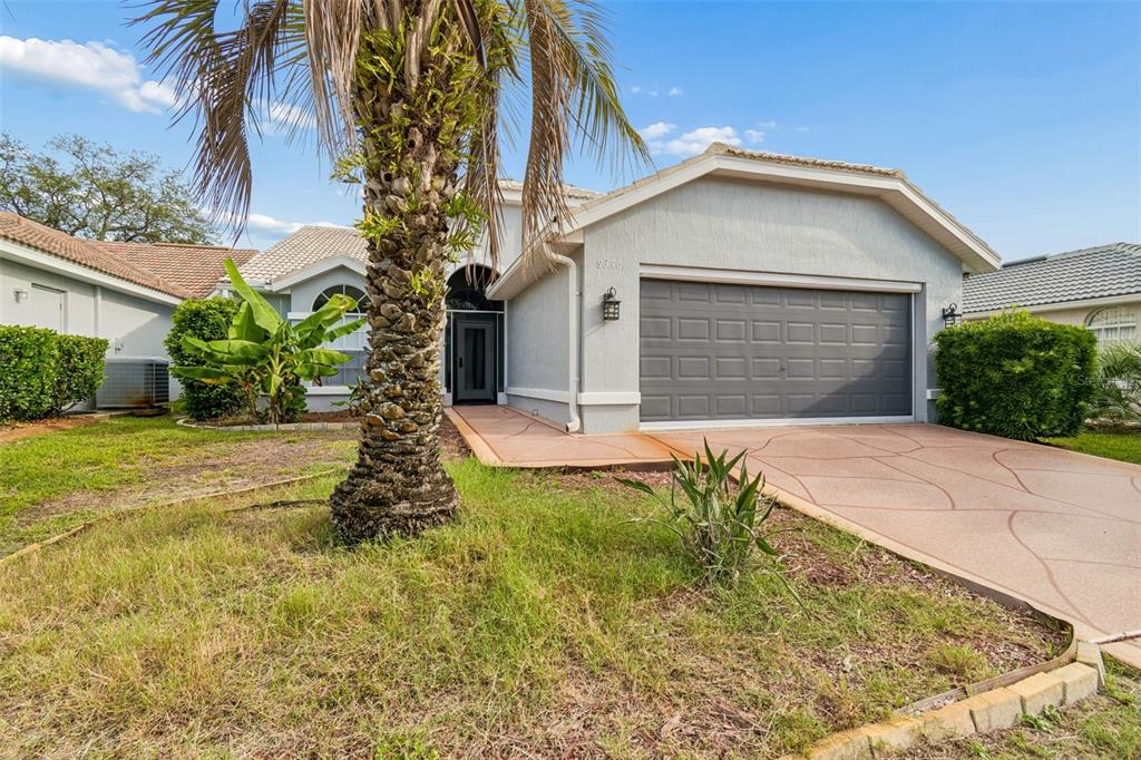 A single-story house with a gray garage, a palm tree, and a patterned concrete driveway — 9376 FRENCH QUARTERS CIRCLE, WEEKI WACHEE, FL