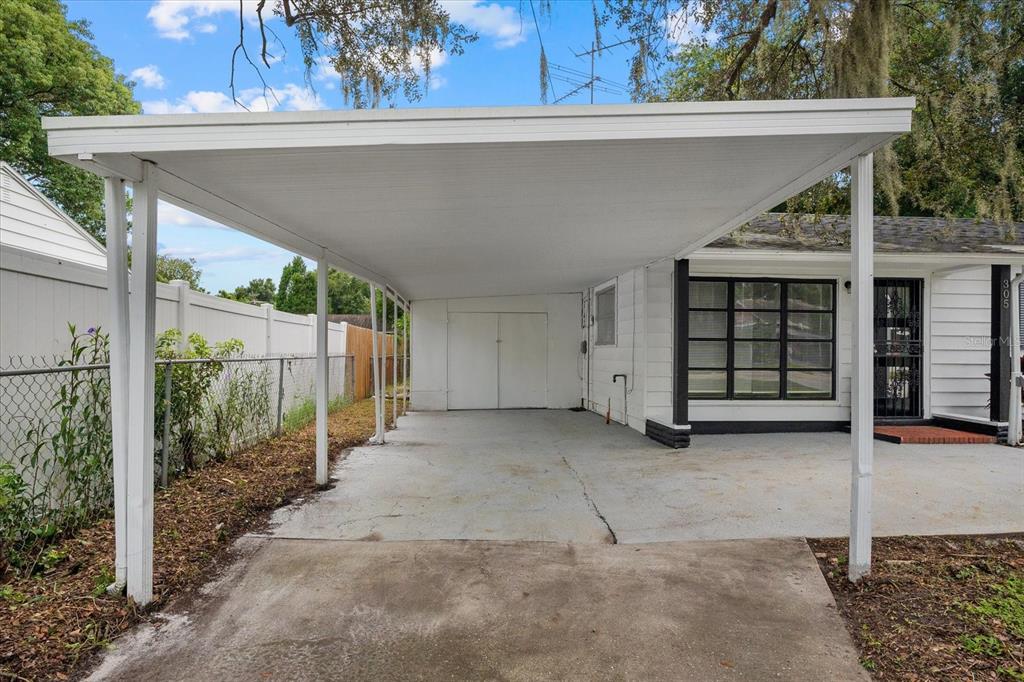 A white carport with a concrete floor is attached to the side of a house — 305 E BOUGAINVILLEA AVENUE, TAMPA, FL