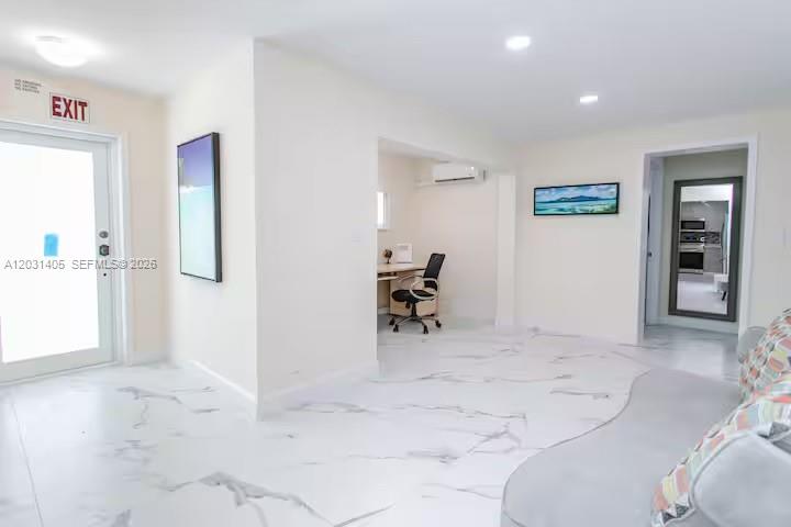 A bright room features white marble-look flooring, an office nook, and a glass-paneled exit door — 1716 Liberty St, Hollywood FL 33020, HOLLYWOOD, FL