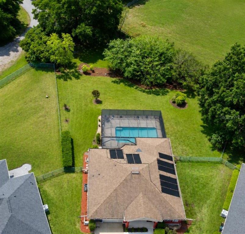 An aerial view shows a house with a screened-in pool enclosure and a large backyard — 6008 SW 103RD LOOP, OCALA, FL