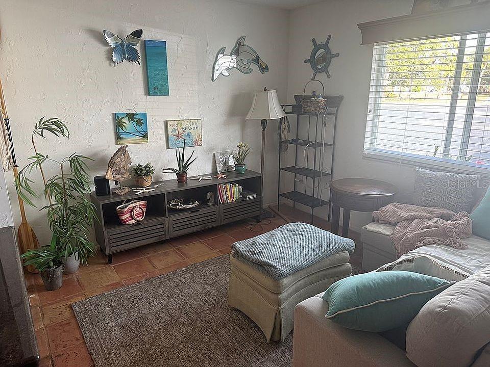 A living room features tile floors, a media console, a sofa, and coastal-themed wall decor — 525 MANATEE COURT UNIT 8, VENICE, FL