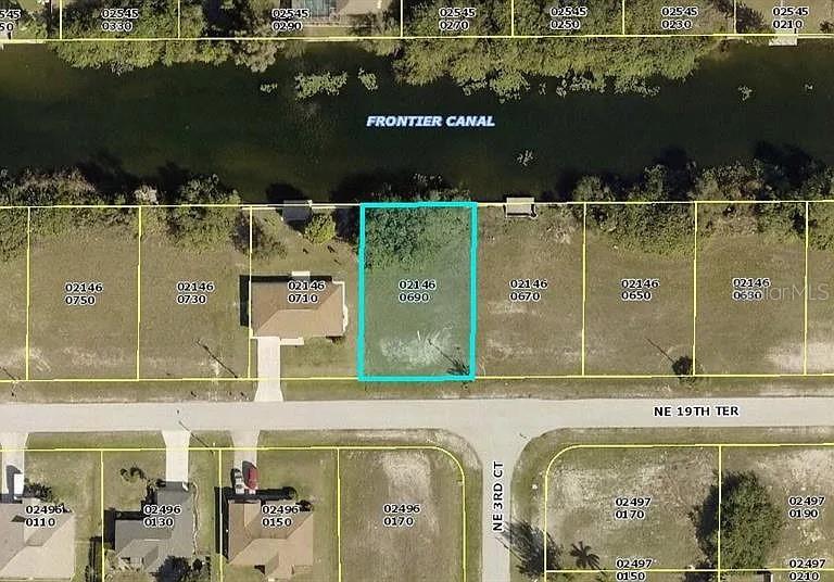 This is an aerial map showing a vacant waterfront lot highlighted in blue along a canal — 335 NE 19TH TERRACE, CAPE CORAL, FL