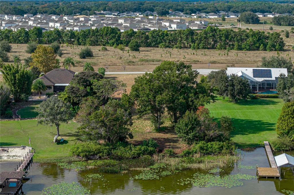 An aerial view shows two houses with large lawns and docks on a lake — 2080 KENNWOOD GROVE LANE, AUBURNDALE, FL