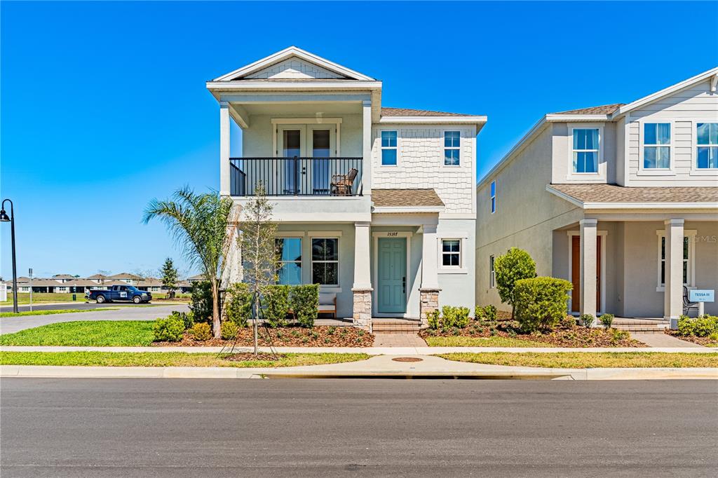 A two-story house with a light blue front door and a second-floor balcony — 15197 BLUE PEACOCK LANE, WINTER GARDEN, FL