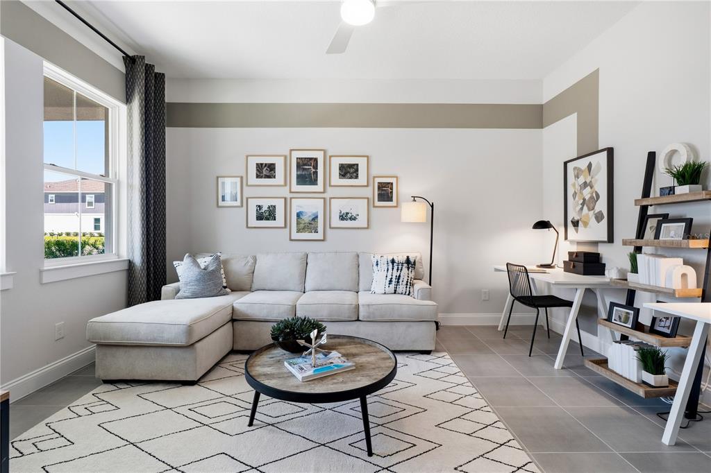 A living room features a sectional sofa, a round coffee table, and a desk area — 15197 BLUE PEACOCK LANE, WINTER GARDEN, FL