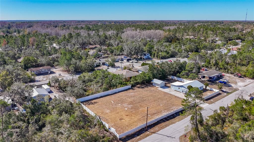 An aerial view shows a fenced, vacant residential lot next to a small house — 12832 MOUNTAIN ROAD, NEW PORT RICHEY, FL